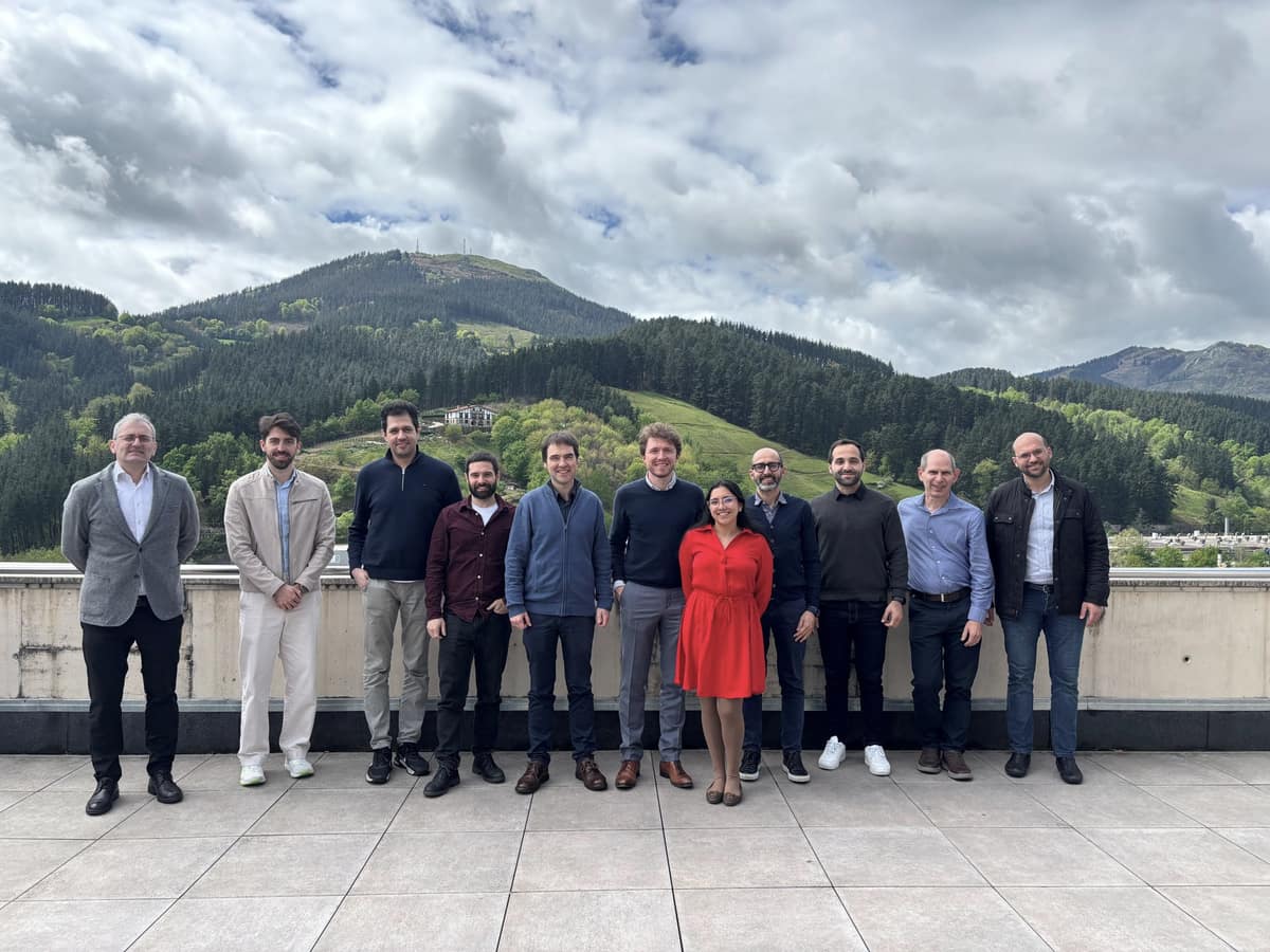 The members of the RELiVE consortium standing side by side on a rooftop terrace, with green wooded hills in the background