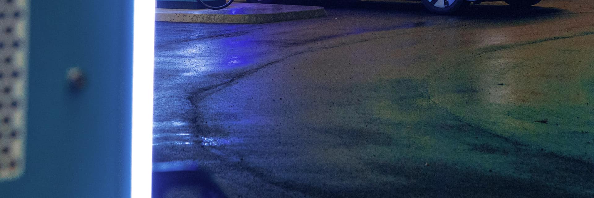 A neon-lit electric vehicle charging plaza at night