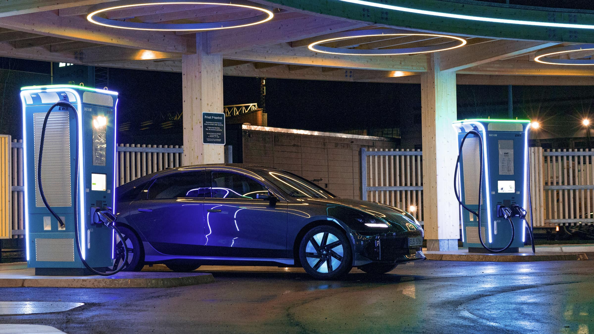 Electric cars charging at a futuristic charging hub at night
