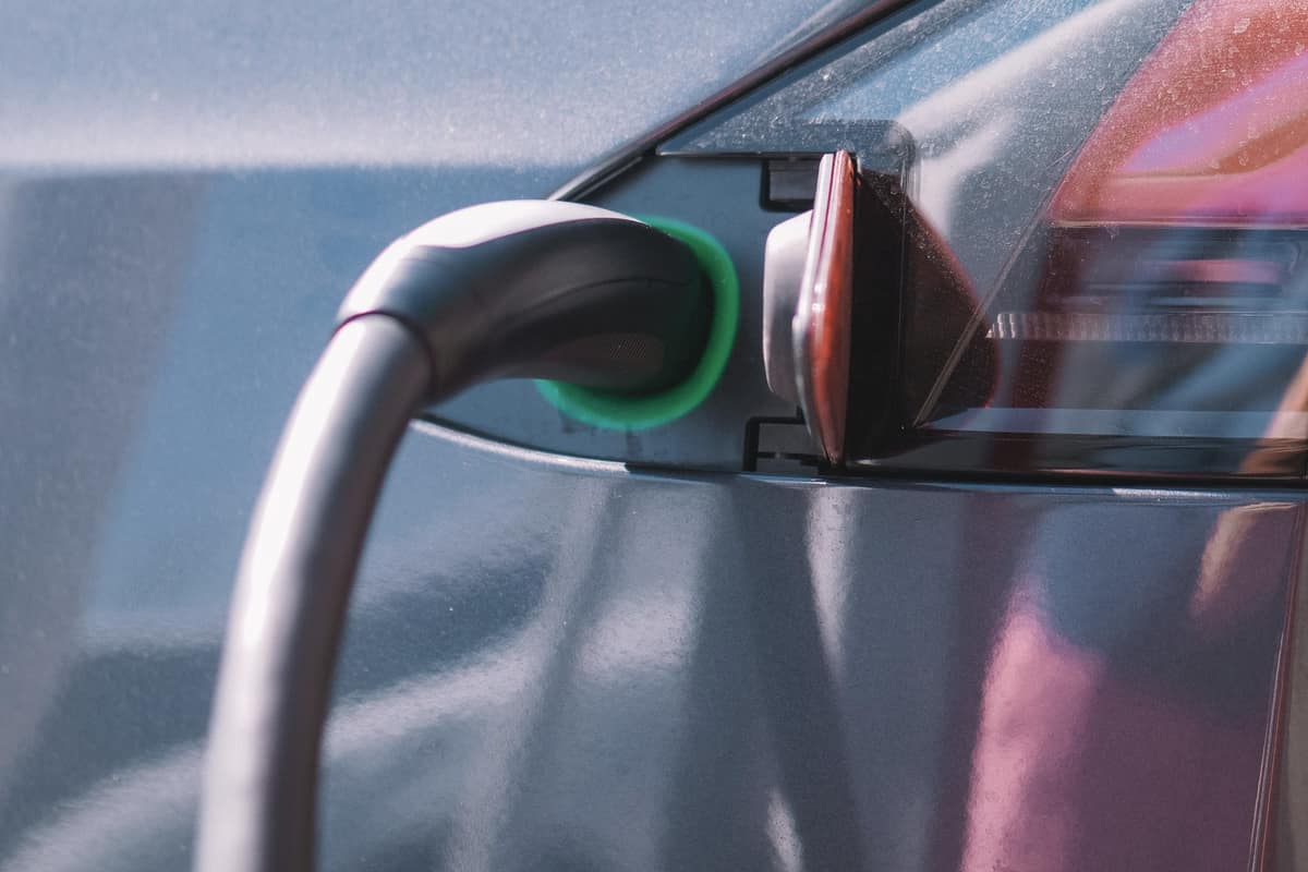 Close-up of an EV charging port with a green status light