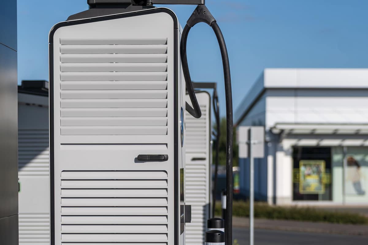 A white cabinet-style charging and storage unit installed outdoors