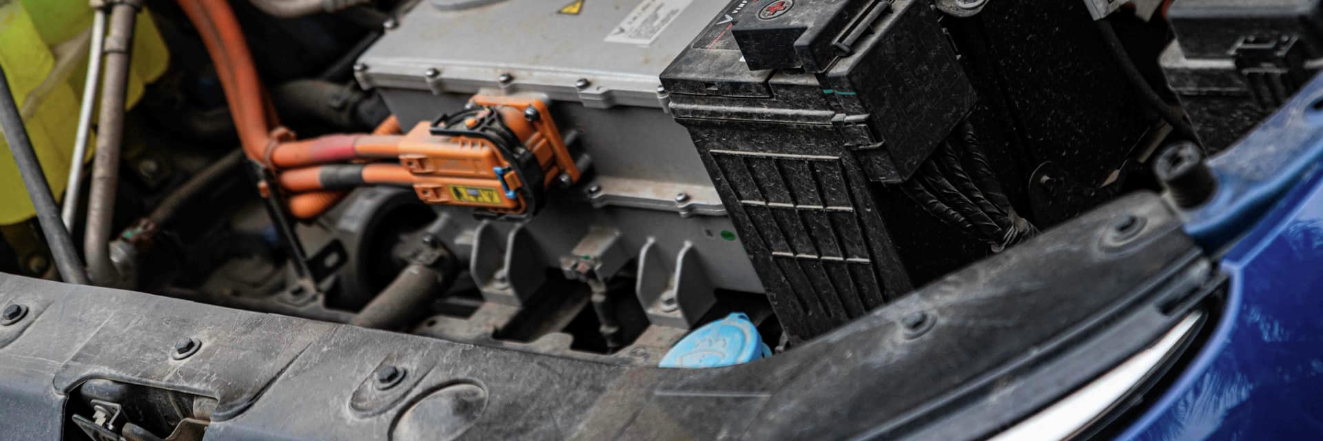 The open engine bay of an electric vehicle showing its battery and power electronics